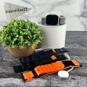 Apple Watch Ultra 49mm with charger base and four straps